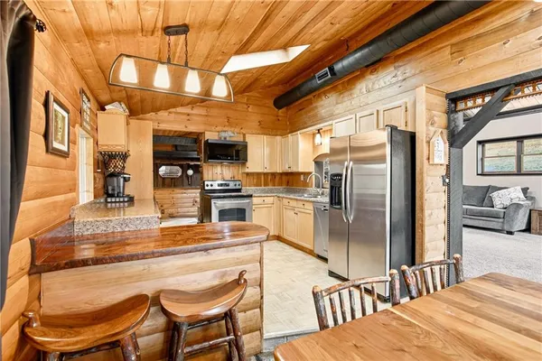a kitchen with stainless steel appliances kitchen island granite countertop a refrigerator and a stove top oven