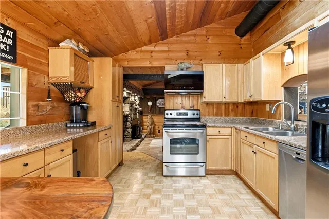 a kitchen with stainless steel appliances kitchen island granite countertop a stove and a sink