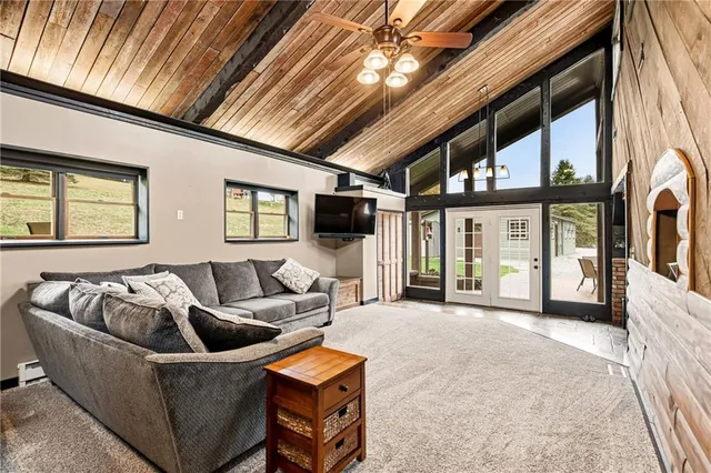 a living room with furniture a flat screen tv and floor to ceiling window