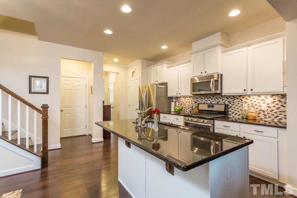 Kitchen boasts gas stove, granite counters, tile backsplash, undercabinet lighting.  Upgraded granite and cabinets.