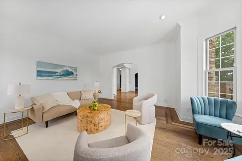 a view of a dining room with furniture a chandelier and wooden floor