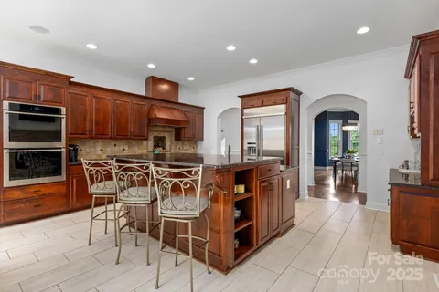 a kitchen with granite countertop a sink stove and refrigerator