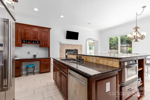 a kitchen with stainless steel appliances granite countertop a stove microwave and sink