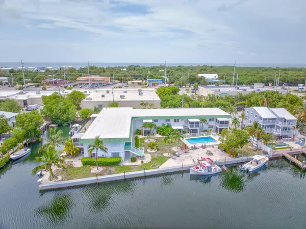 an aerial view of a house with a garden and lake view