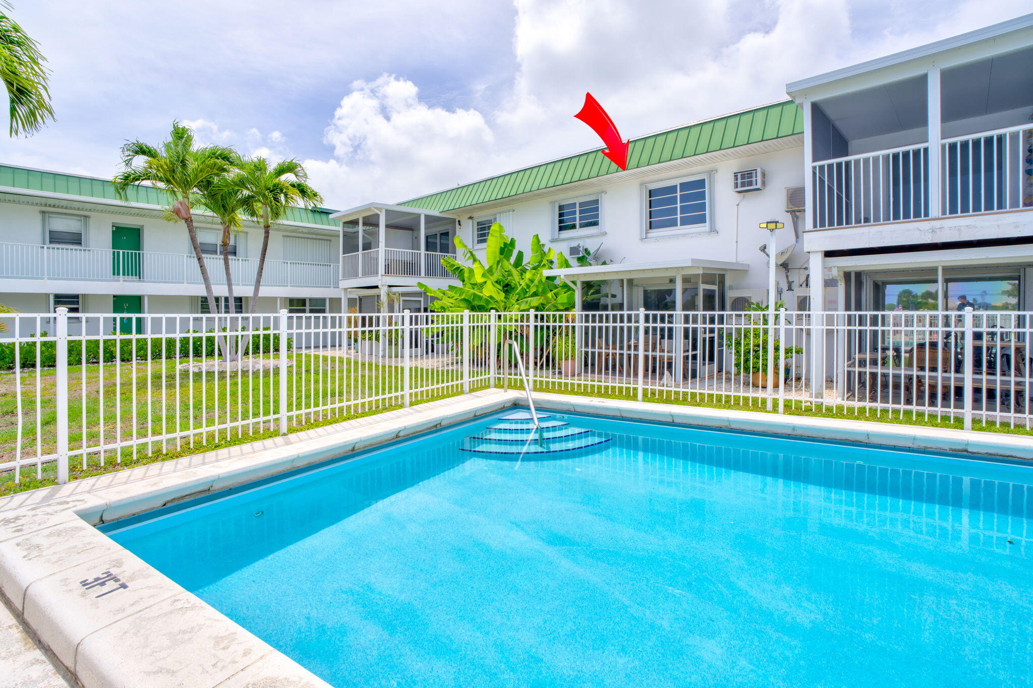 5301 Ocean Terrace, Unit 6 Marathon, FL 33050 - Photo 11 of 38 a view of a house with a swimming pool and a yard