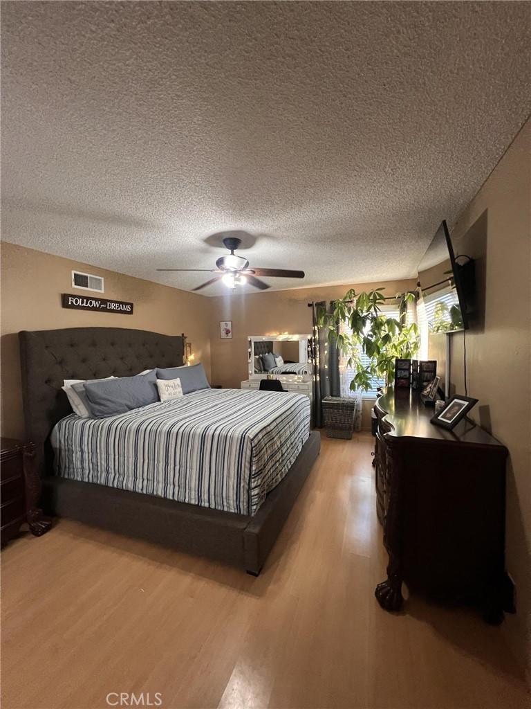 591 North Smoke Tree Avenue Rialto, CA 92376 - Photo 13 of 48 a spacious bedroom with a bed and a chandelier