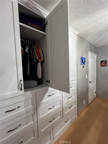 a view of walk in closet with clothes and shoes