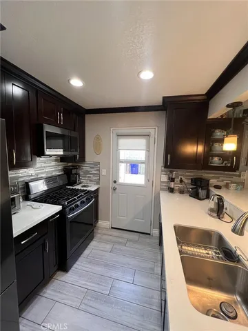 a kitchen with granite countertop a sink and stainless steel appliances