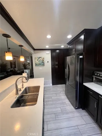 a view of a kitchen with a sink and a refrigerator