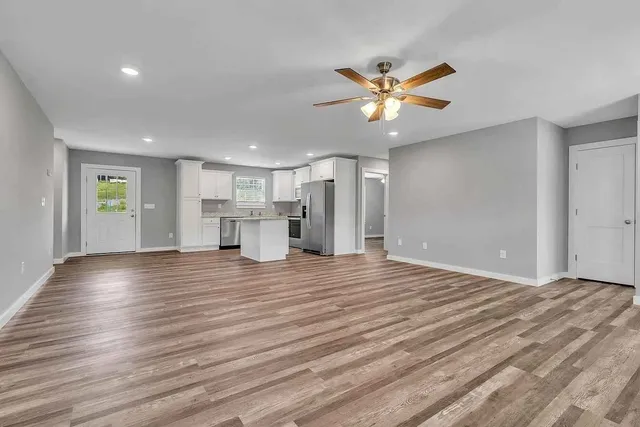 a view of empty room with wooden floor and window