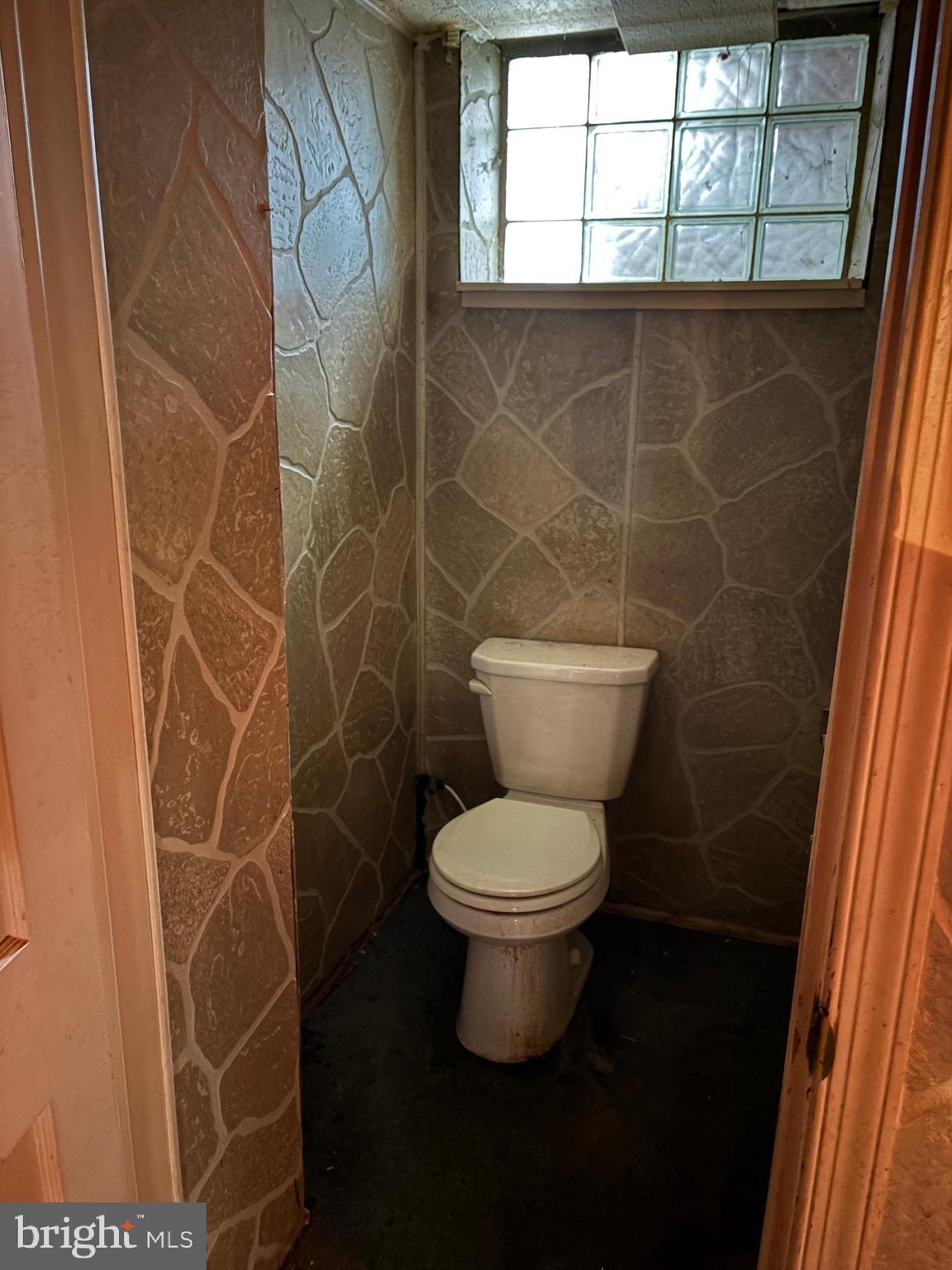 7832 Rockbourne Road Baltimore, MD 21222 - Photo 17 of 20 a white toilet sitting next to a window and a shower