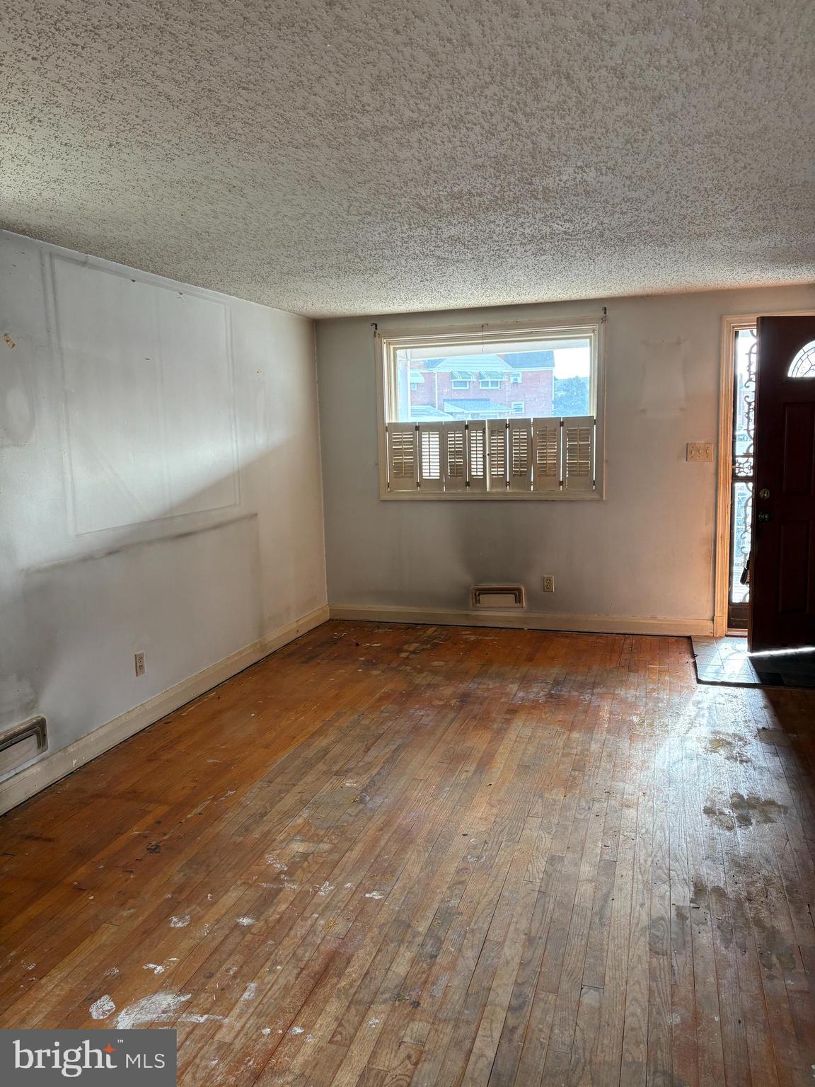 7832 Rockbourne Road Baltimore, MD 21222 - Photo 4 of 20 an empty room with wooden floor and windows