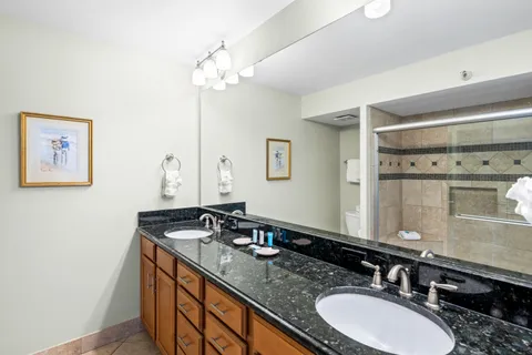 a bathroom with a granite countertop sink and a mirror