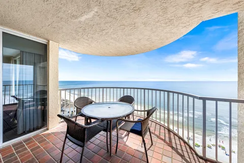 a view of balcony with wooden floor table and chairs