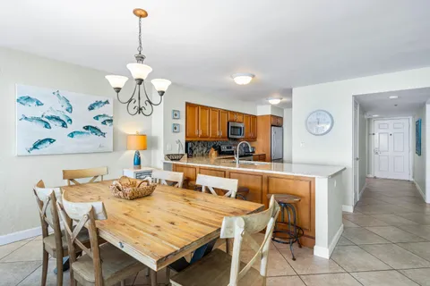 a view of a dining room with furniture a chandelier and wooden floor