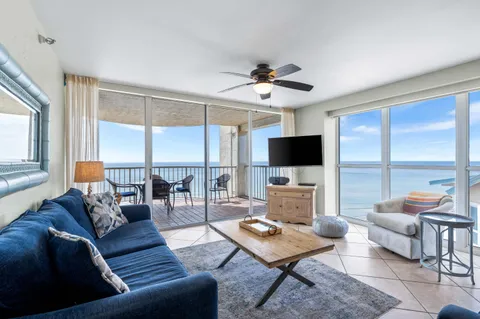 a living room with furniture a flat screen tv and a large window