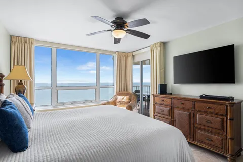 a bedroom with a bed and a flat tv screen on dresser