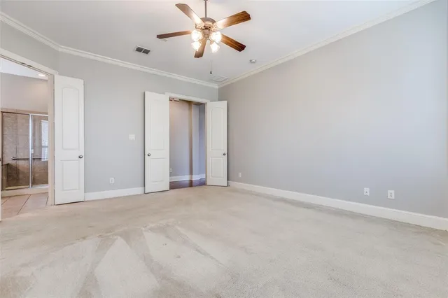 an empty room with closet and a chandelier fan