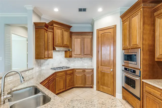 a kitchen with stainless steel appliances granite countertop a sink refrigerator and cabinets