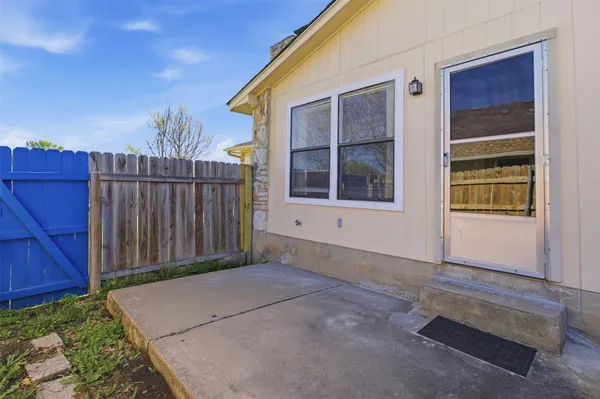 a view of backyard with window and wooden fence
