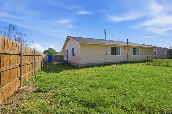 a view of backyard with potted plants and wooden fence