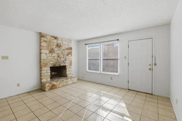 a view of an empty room with a fireplace and a window