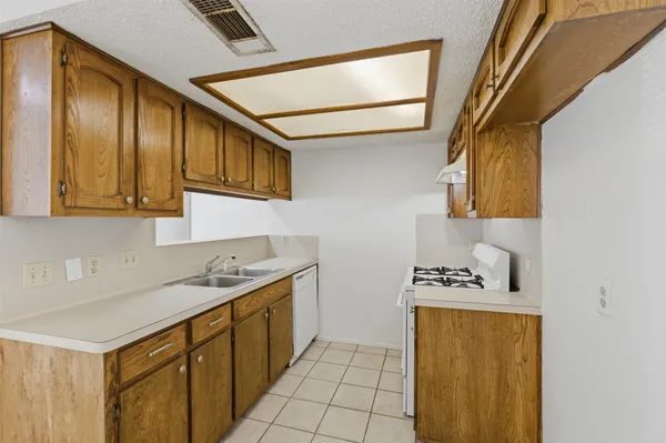 a kitchen with stainless steel appliances granite countertop a sink a stove and a refrigerator