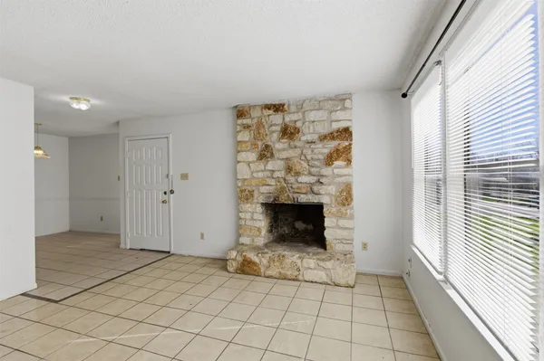 a view of an empty room with a fireplace and a window