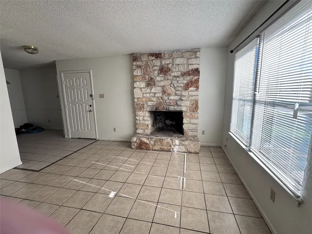 a view of empty room with fireplace and windows
