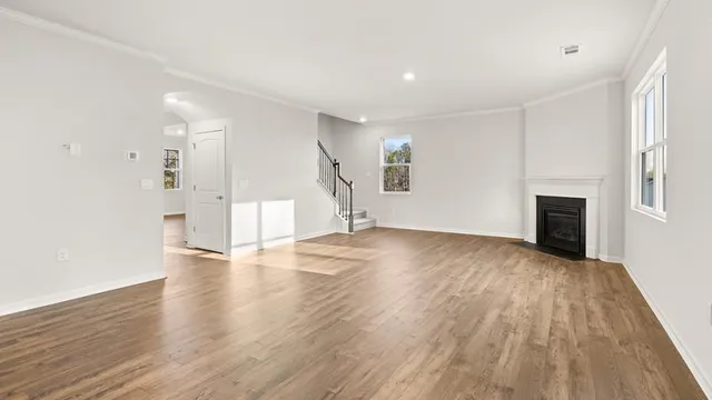 a view of empty room with wooden floor and fireplace