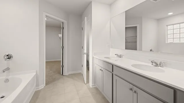 a spacious bathroom with a tub sink and mirror