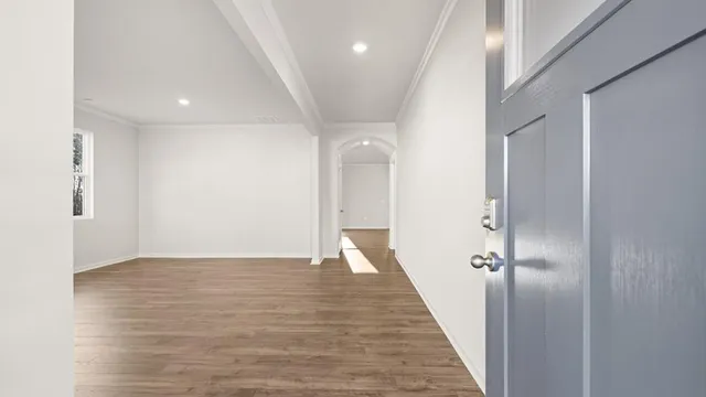 a view of a hallway with wooden floor and staircase