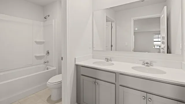 a bathroom with a toilet a sink a mirror a bathtub and vanity