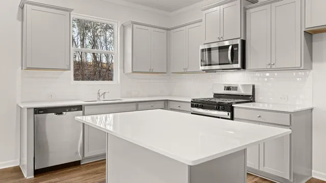 a kitchen with stainless steel appliances a sink a stove and microwave