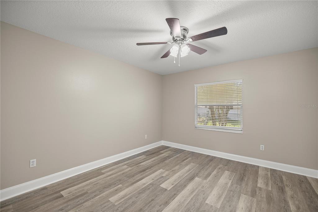 46 Teak Run Ocala, FL 34472 - Photo 14 of 26 an empty room with wooden floor fan and windows