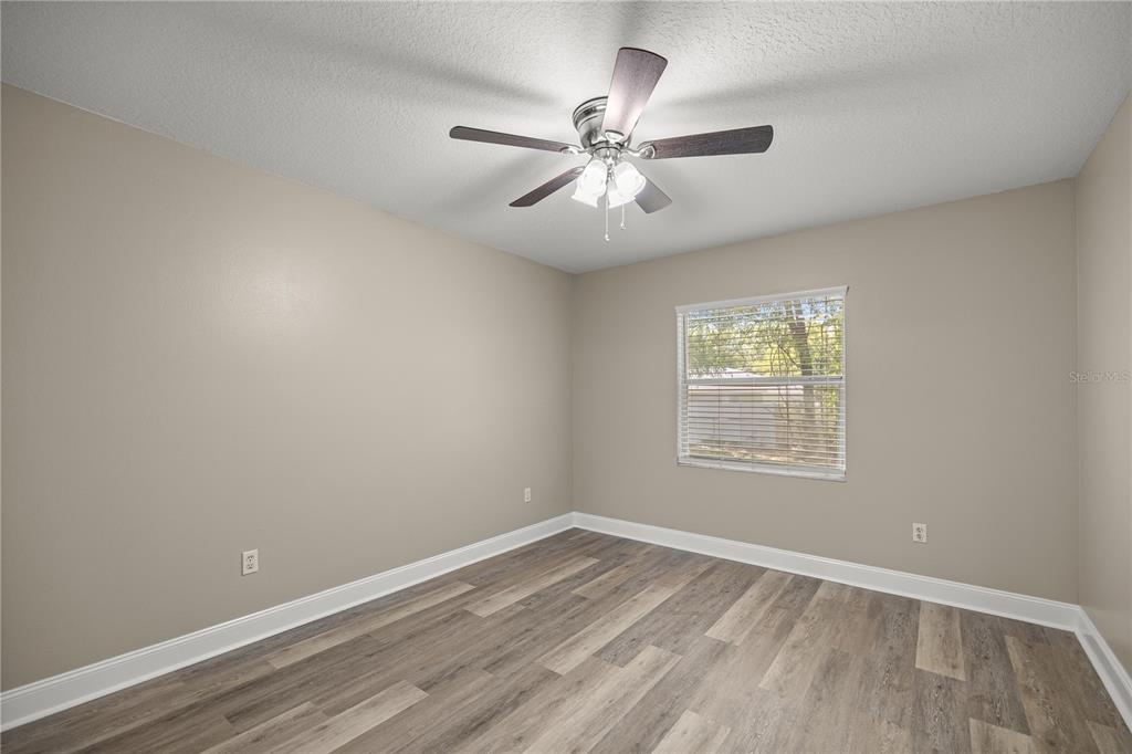 46 Teak Run Ocala, FL 34472 - Photo 18 of 26 an empty room with wooden floor fan and windows