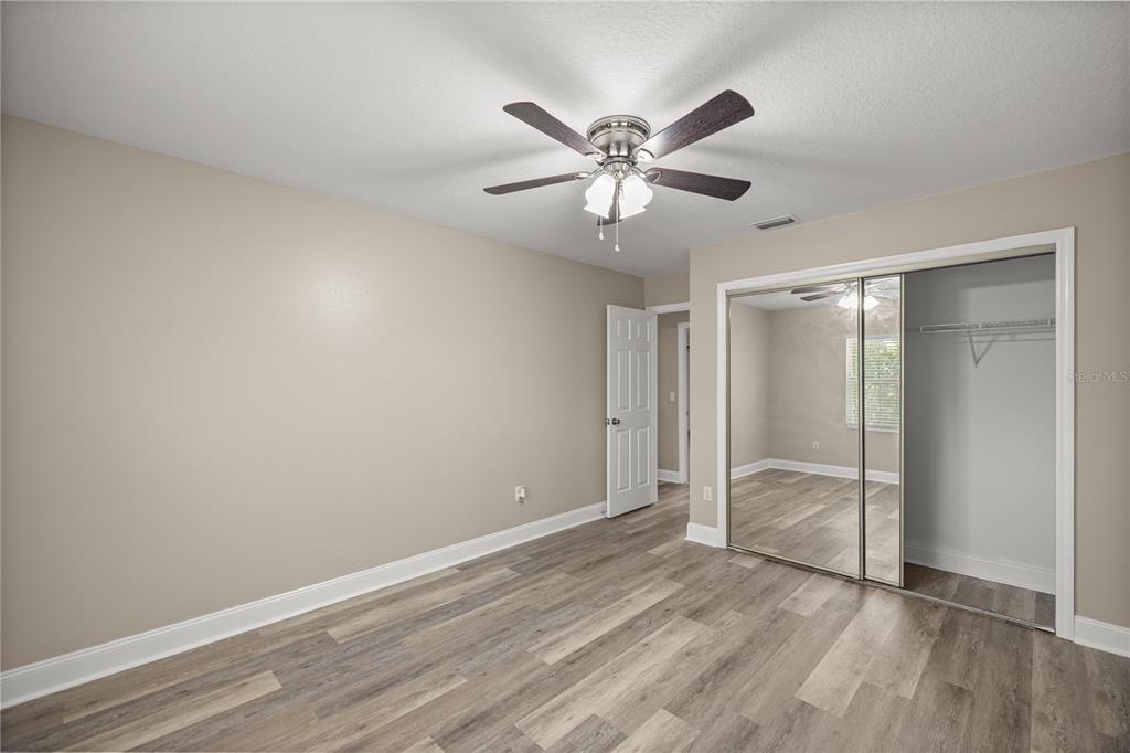46 Teak Run Ocala, FL 34472 - Photo 20 of 26 an empty room with wooden floor and fan