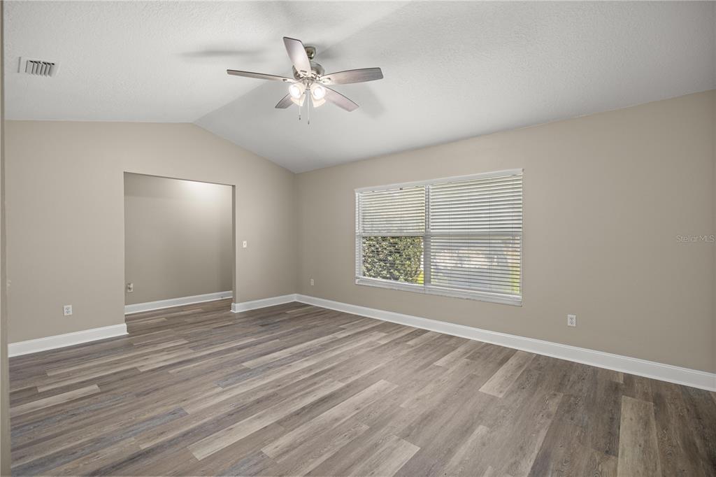 46 Teak Run Ocala, FL 34472 - Photo 4 of 26 an empty room with wooden floor chandelier fan and windows