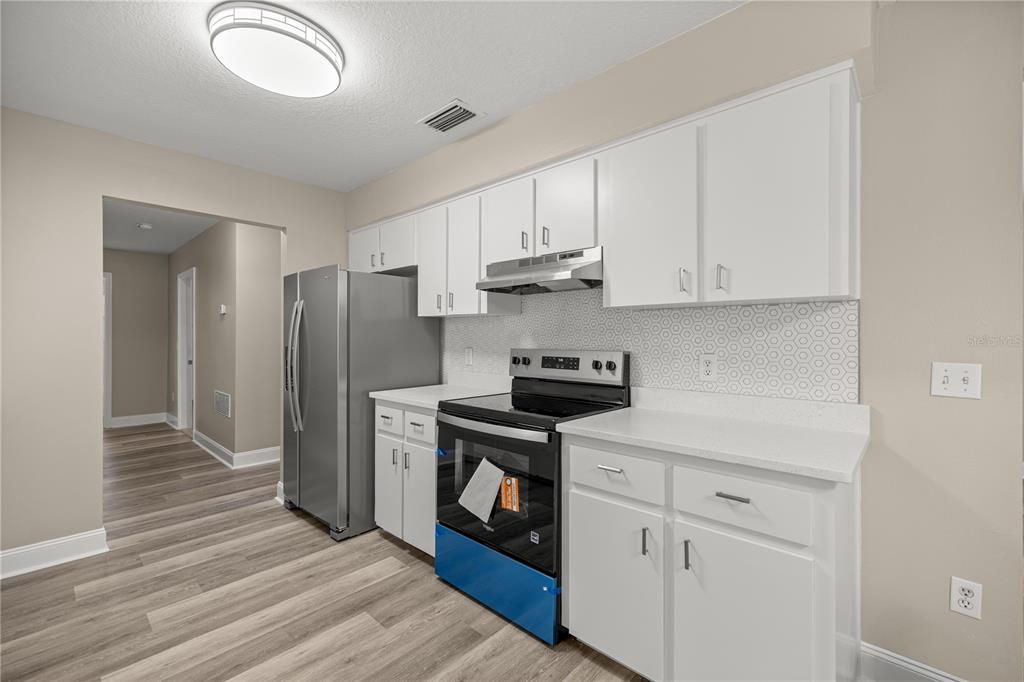 46 Teak Run Ocala, FL 34472 - Photo 8 of 26 a kitchen with stainless steel appliances granite countertop a stove a refrigerator and a sink with white cabinets