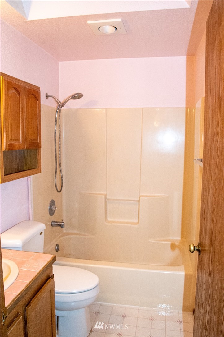 8723 Hawks Glen Loop Southeast Olympia, WA 98513 - Photo 6 of 12 a bathroom with a granite countertop bathtub shower sink vanity and toilet