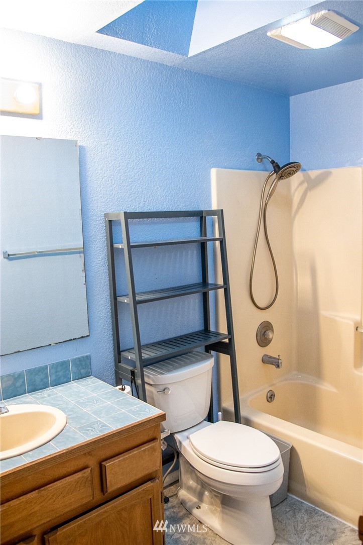 8723 Hawks Glen Loop Southeast Olympia, WA 98513 - Photo 9 of 12 a bathroom with a granite countertop sink toilet and shower