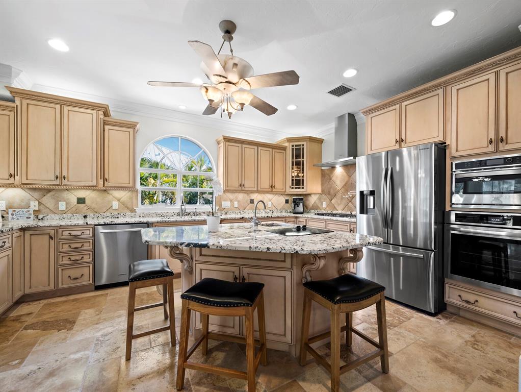 651 Broadway Street Longboat Key, FL 34228 - Photo 16 of 75 a kitchen with granite countertop a center island stainless steel appliances cabinets and a counter top space