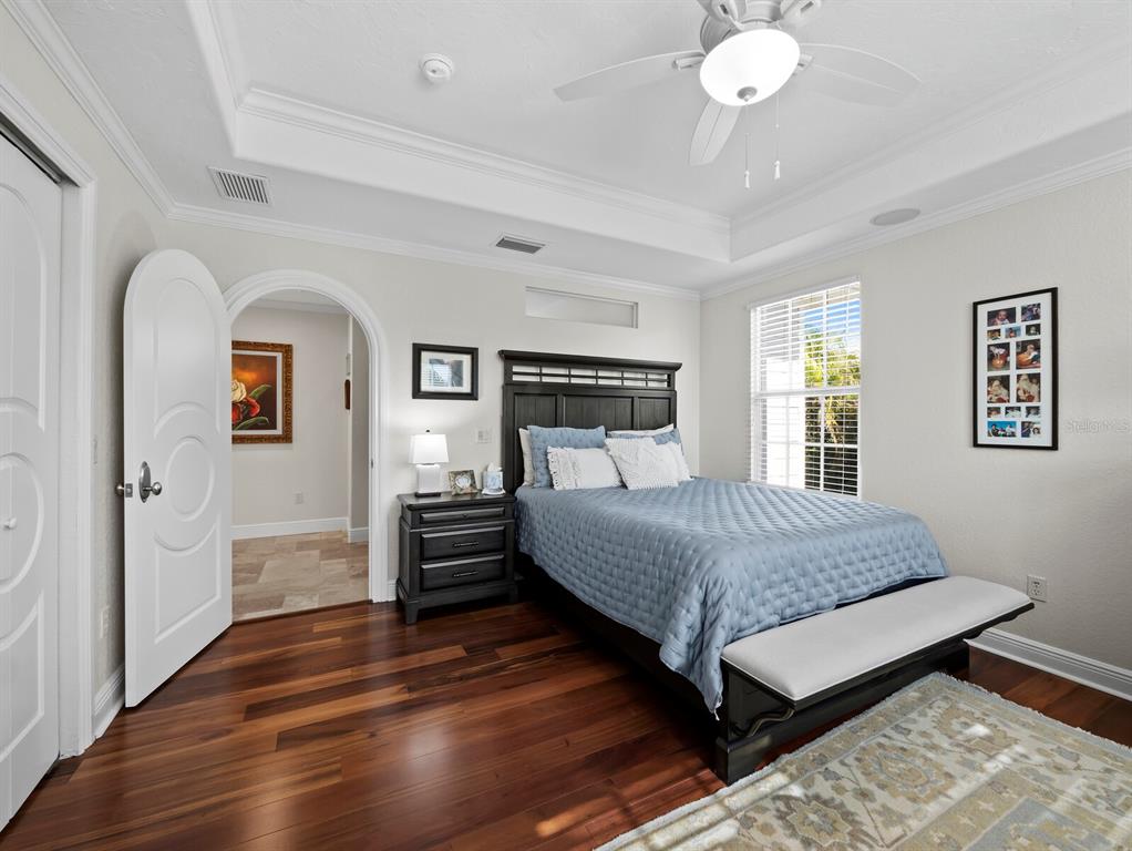 651 Broadway Street Longboat Key, FL 34228 - Photo 24 of 75 a bedroom with a bed and dresser with wooden floor