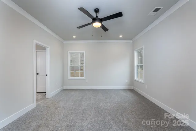 an empty room with ceiling fan and window