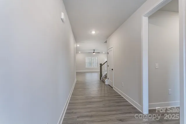 an empty room with wooden floor ceiling fan and windows