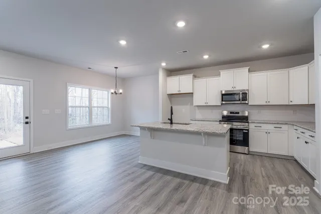 a kitchen with stainless steel appliances granite countertop a sink stove and cabinets