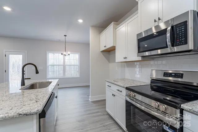 a view of a kitchen island a sink wooden floor and a cabinet
