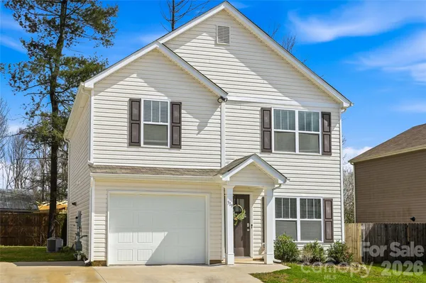a view of a white house next to a yard