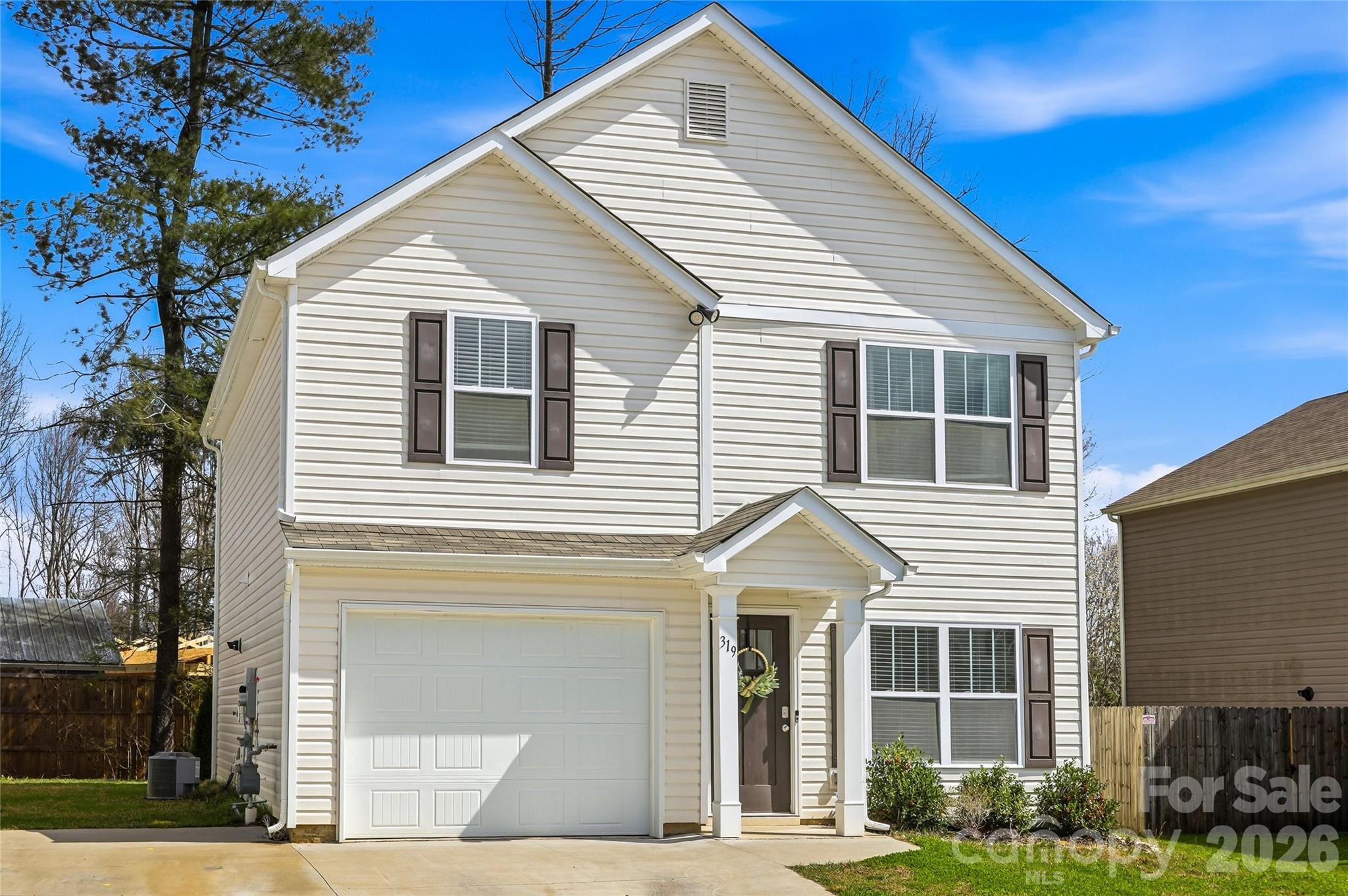 a view of a white house next to a yard