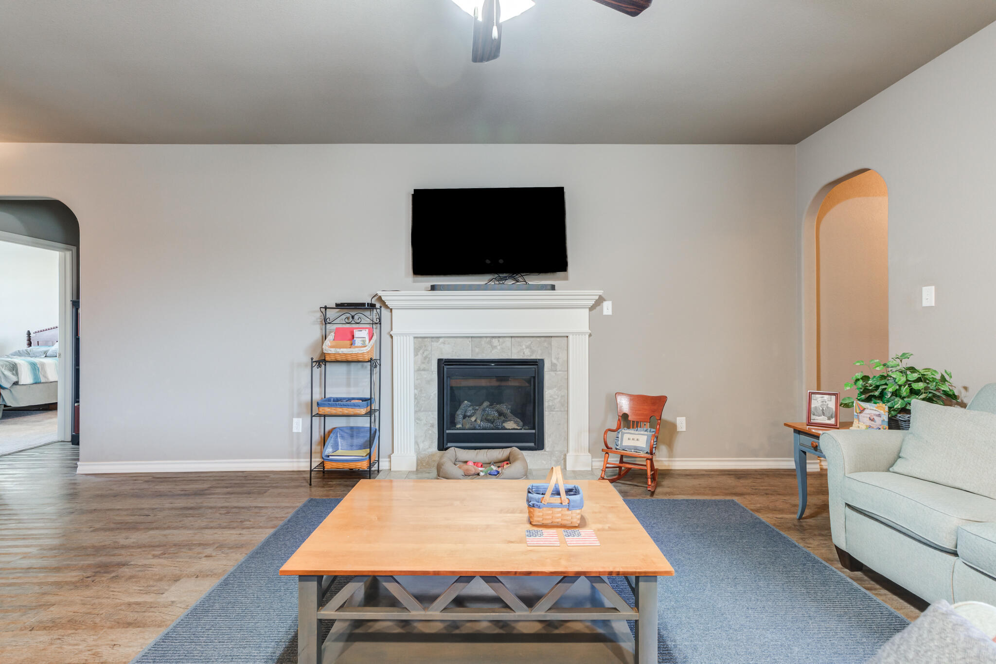 5219 Kemper Street Lubbock, TX 79416 - Photo 13 of 38 a living room with furniture a flat screen tv and a fireplace